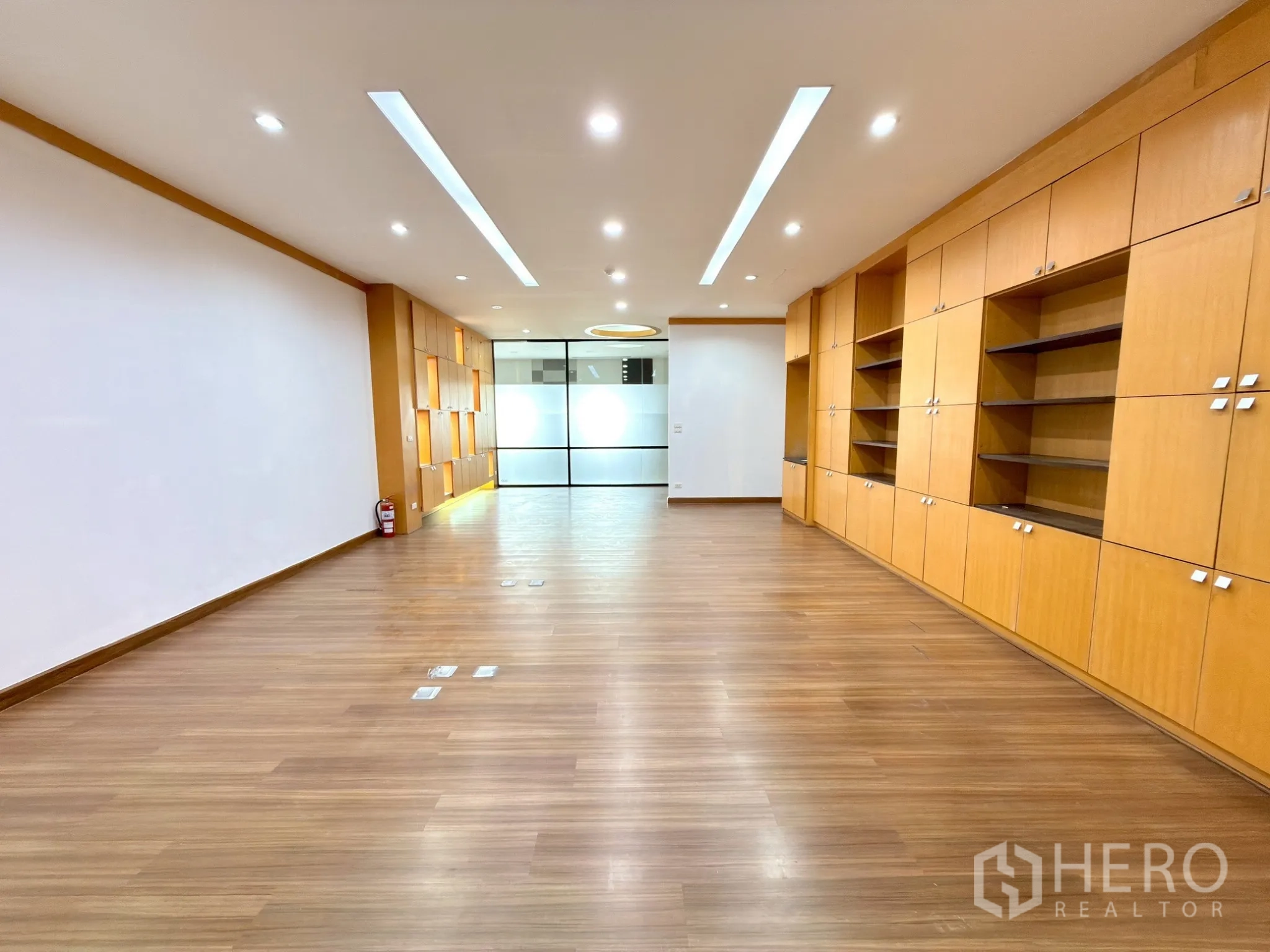 ออฟฟิศ for rent in Watthana, Bangkok - โซนกลางออฟฟิศพร้อมตู้เก็บของบิลท์อิน และประตูกระจกฝ้าที่ปลายห้อง.