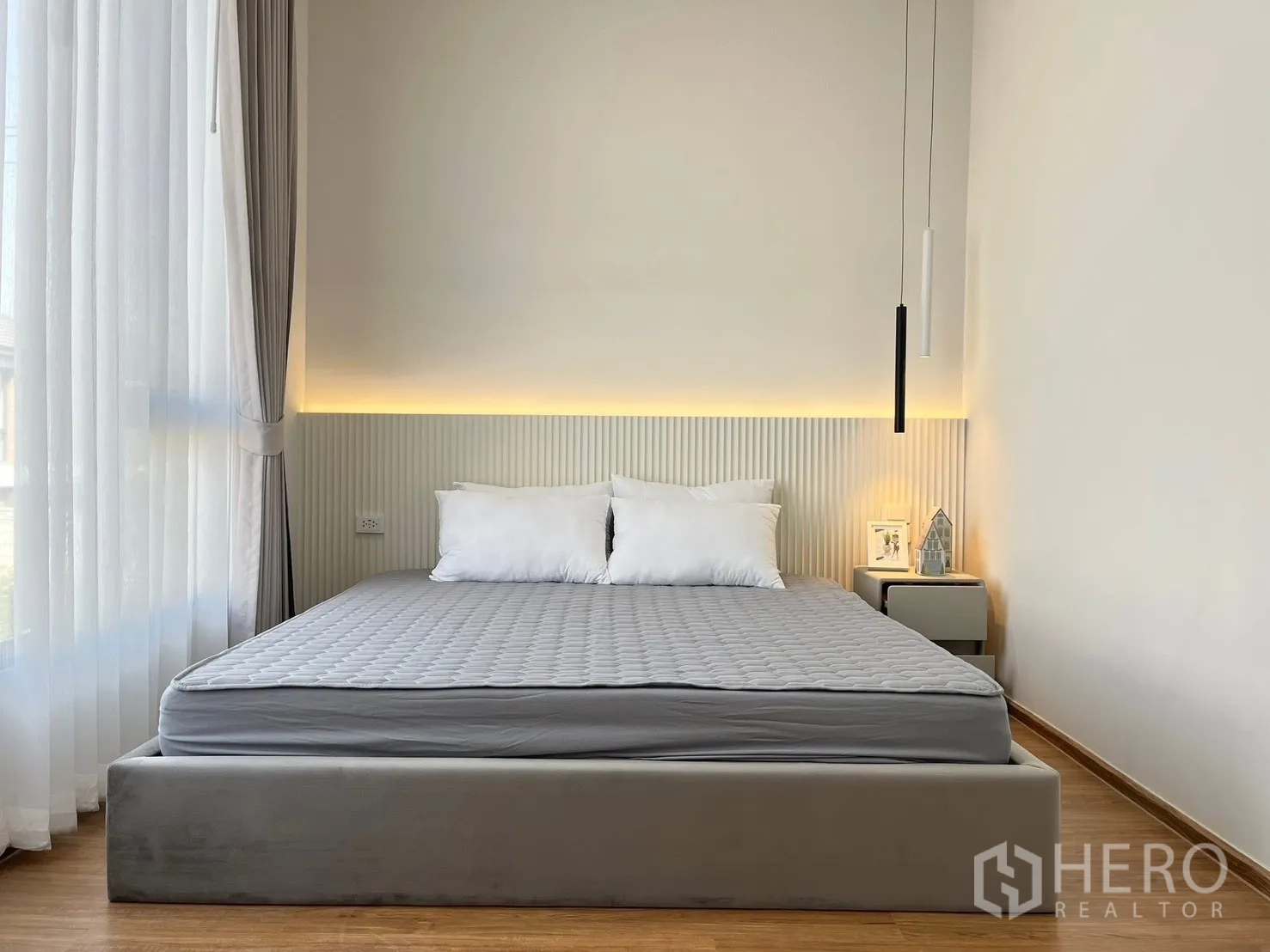 Townhouse for rent in Bang Phli, Samut Prakan - Master bedroom with upholstered bed, soft backlighting, bedside tables, and sheer curtains.