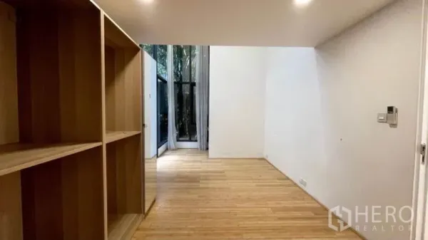 公寓 出租在Watthana, Bangkok - 卧室或书房配木质开放书架，靠近高窗可见私家庭院