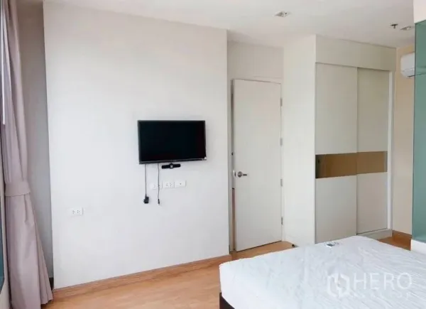 公寓 出租在Watthana, Bangkok - 采光充足的卧室，墙挂电视、衣柜与浅色木地板。