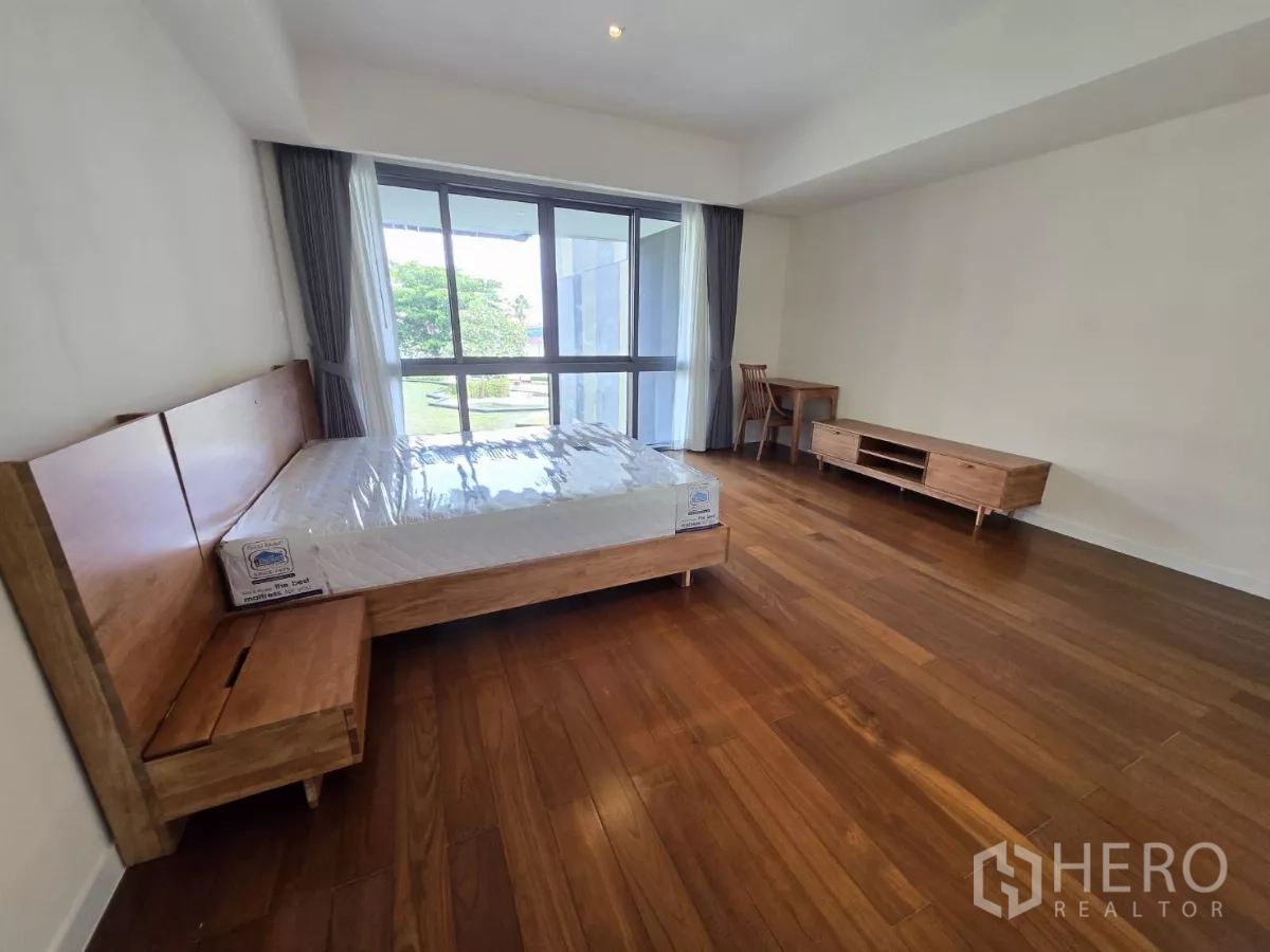 公寓 出租在Yan Nawa, Bangkok - 宽敞主卧，双人床与书桌，通过大窗可见绿景。