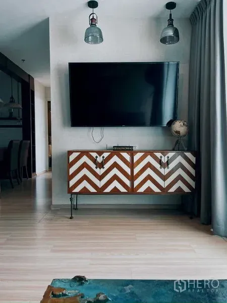 Condominium for rent in Suan Luang, Bangkok - Wall-mounted TV above a chevron console in a modern living area
