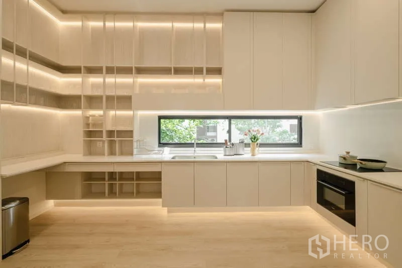 Detached House for rent in Saphan Sung, Bangkok - Light-toned kitchen with extensive cabinetry and under-cabinet lighting.
