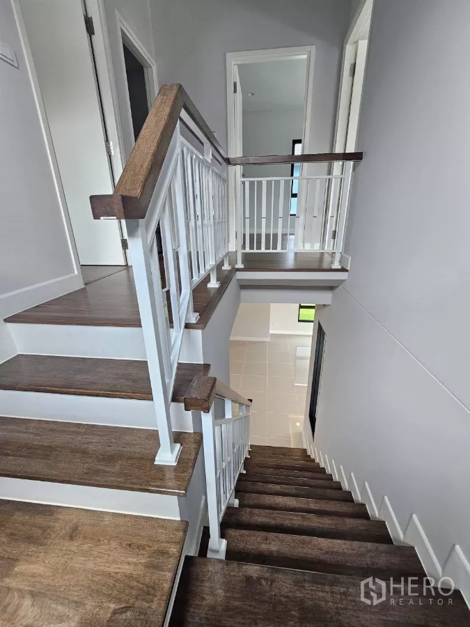 Detached House for sale in Lam Luk Ka, Pathum Thani - Wooden staircase with white balustrade viewed from above.