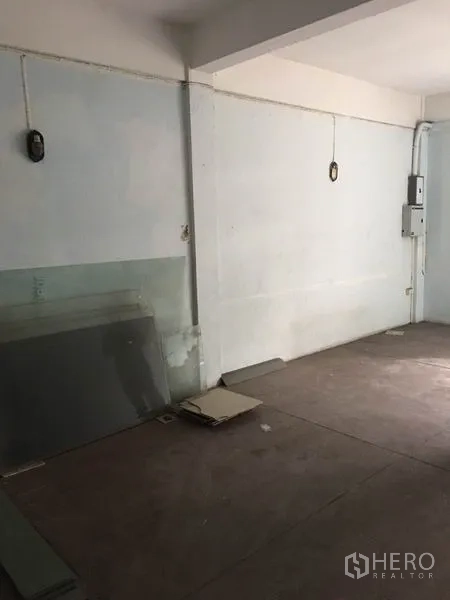 Shophouse for rent in Khlong Toei, Bangkok - Empty room with concrete floor and exposed electrical panel along the wall.
