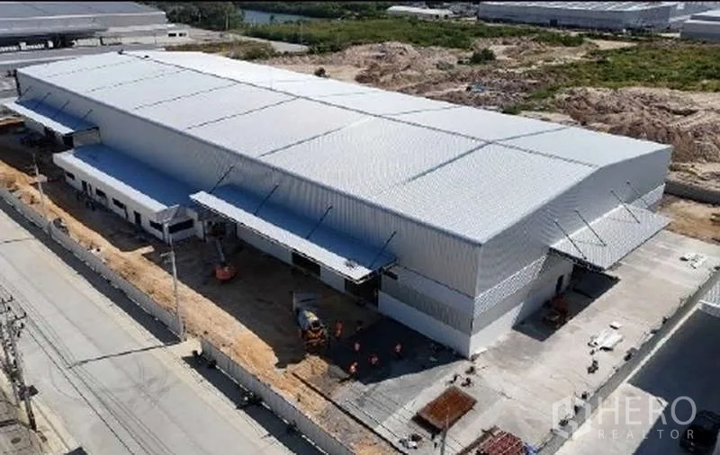 货栈 出租在Mueang Rayong, Rayong - 新建物流仓库斜向航拍，多处装卸月台与卡车通道清晰可见。