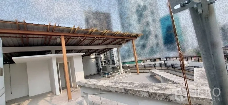 零售空间 出租 - 屋顶雨棚与机电设备，远景为城市楼群。