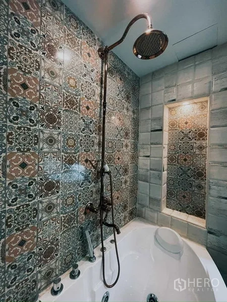 Condominium for rent in Suan Luang, Bangkok - Bathroom with patterned tiles, rain shower, and bathtub
