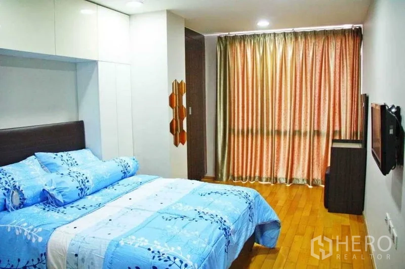 公寓 出租在Phaya Thai, Bangkok - 主卧宽敞，蓝色床品、内置衣柜、木地板与遮光窗帘。