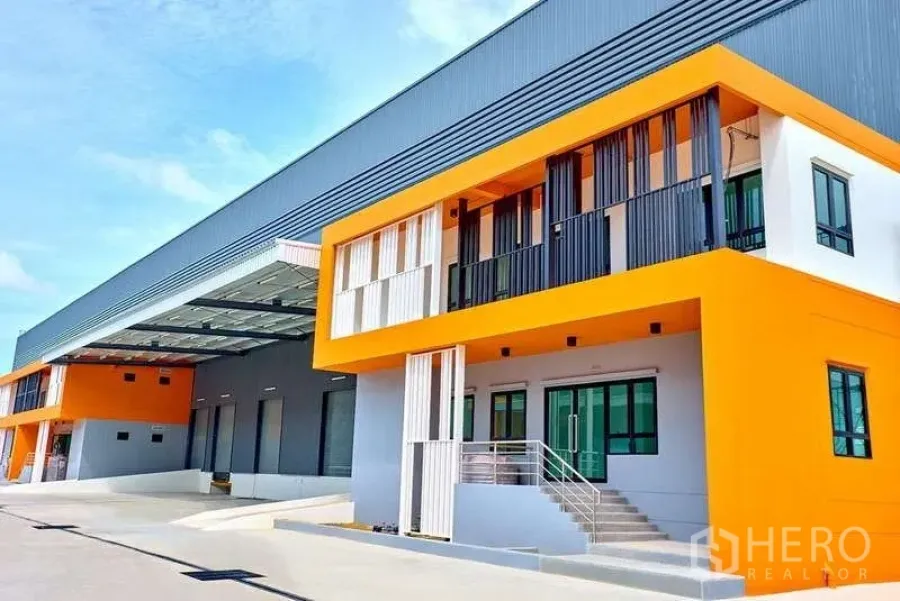 Factory for rent in Bang Phli, Samut Prakan - Modern factory exterior with orange office block and covered loading bays