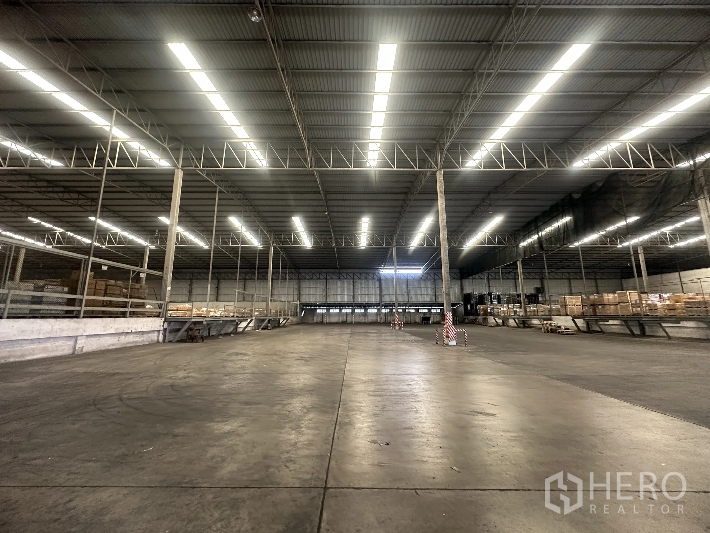 Warehouse for rent in Bang Pa-in, Phra Nakhon Si Ayutthaya - Open storage hall with concrete floor, skylights, and multiple loading platforms.