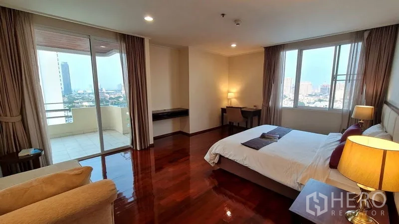 房间 出租在Watthana, Bangkok - 大卧室设双侧推拉门通往阳台，配高窗帘与柔光。