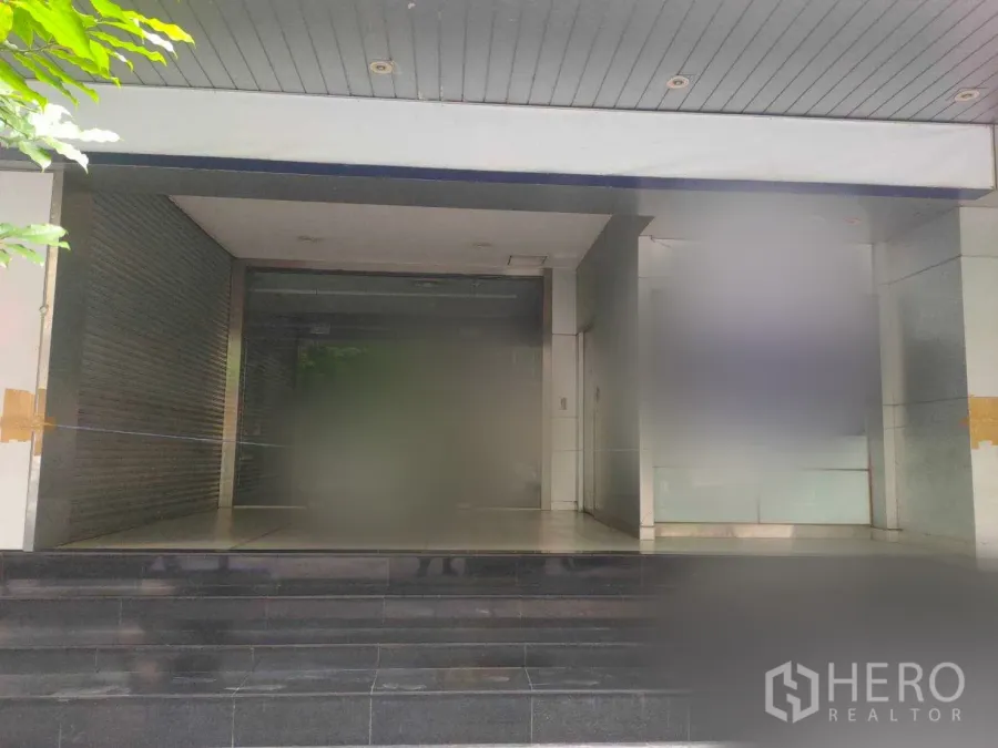 สำนักงาน ให้เช่าในYan Nawa, Bangkok - ทางเข้าอาคารสำนักงานพร้อมประตูกระจก บันไดหินสีเข้ม และช่องม้วนปิดด้านข้าง ในกรุงเทพฯ