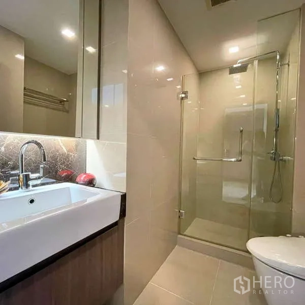 Condominium for rent - Modern bathroom with vanity and glass-enclosed shower.
