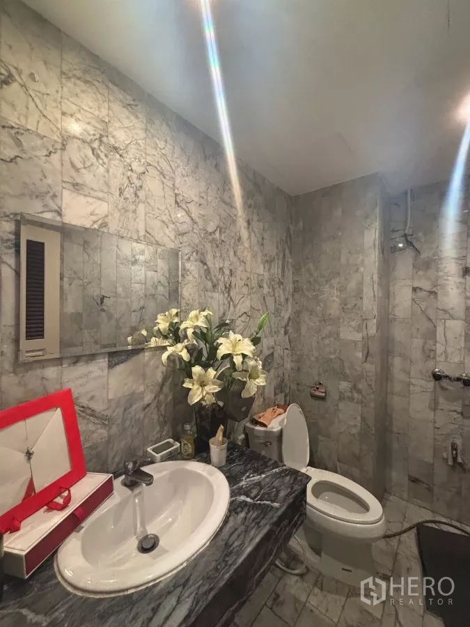 Shophouse for rent in Watthana, Bangkok - Marble-tiled bathroom featuring a sink, toilet and walk-in shower.