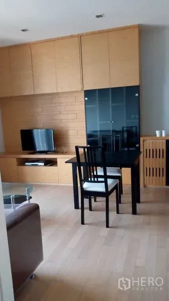 公寓 出租在Watthana, Bangkok - 客厅木质一体柜、电视与餐桌椅，瓦他那区公寓。