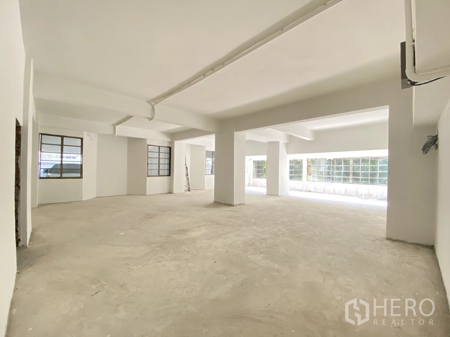 พื้นที่ขายปลีก for rent in Watthana, Bangkok - พื้นที่สว่าง มีช่องหน้าต่างหลายบาน คานเพดาน และท่อเดินสายไฟ.