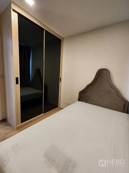 公寓 出租在Khlong Toei, Bangkok - 卧室配软包床与镜面推拉衣柜，顶置筒灯照明。