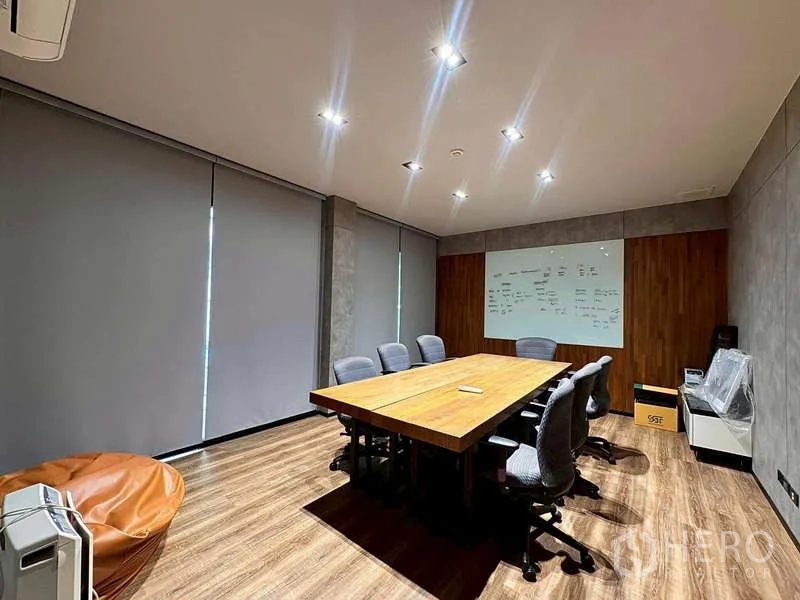Warehouse for rent in Prawet, Bangkok - Meeting room with long wooden table, chairs, whiteboard, and blinds.