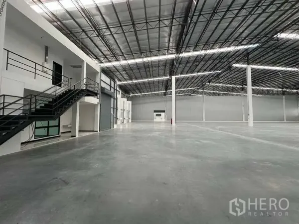 Warehouse for rent in Bang Phli, Samut Prakan - Warehouse floor showing mezzanine office, staircase and large roller shutter door.