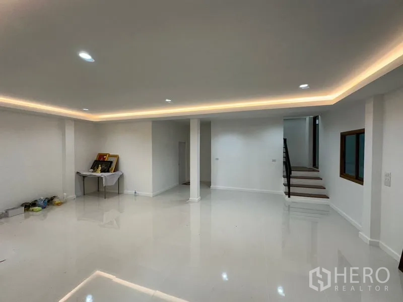Warehouse for rent in Lam Luk Ka, Pathum Thani - Clean office space with cove lighting, columns and a staircase leading to the upper floor.
