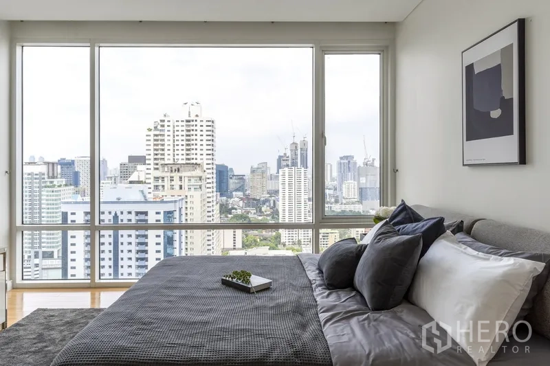 公寓 出租在Watthana, Bangkok - 卧室另一角度，落地窗与灰色寝具，视野开阔。