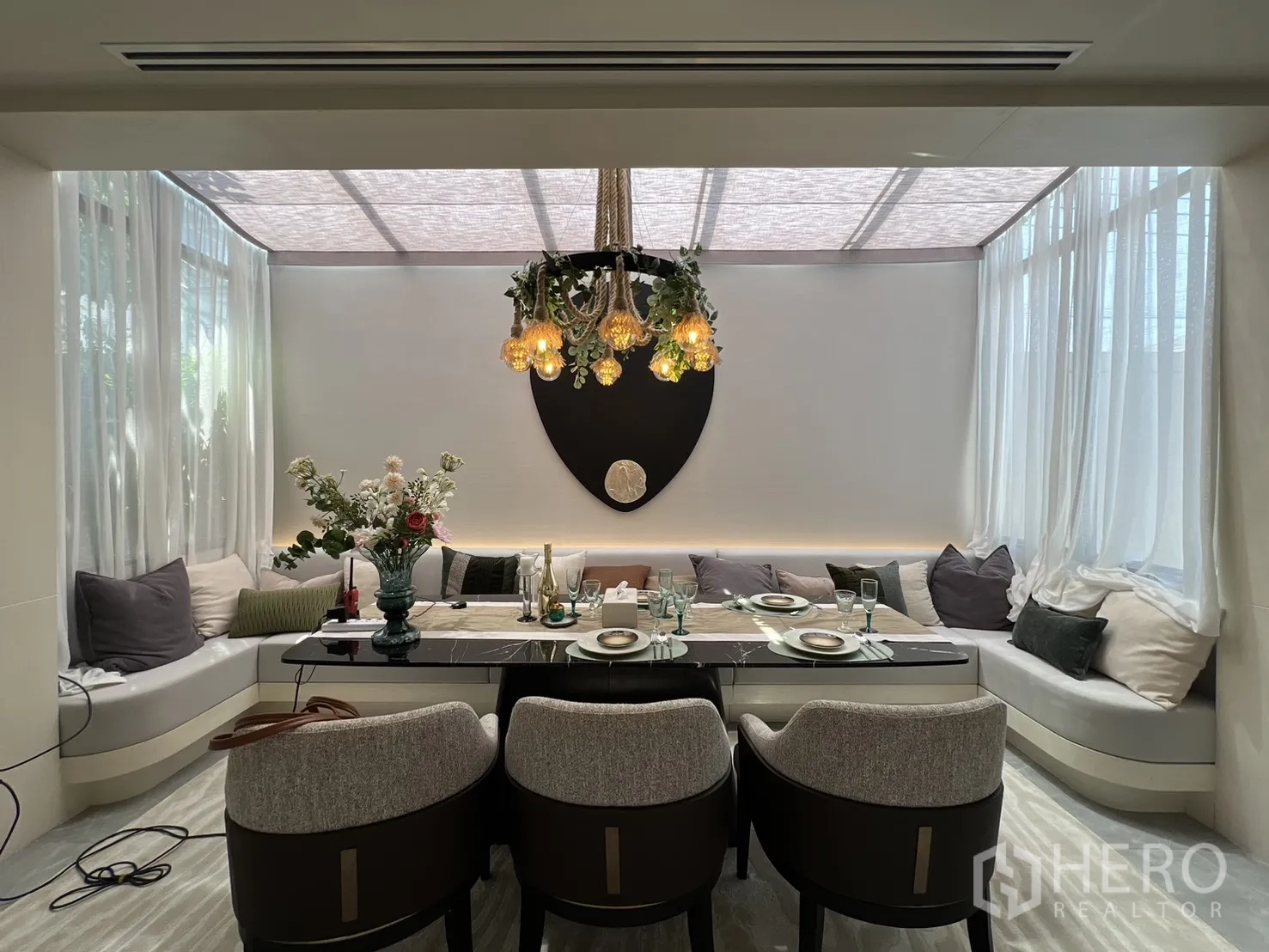 Semi-detached House for sale in Yan Nawa, Bangkok - Dining nook with wraparound bench seating, elegant chandelier, and soft natural light.