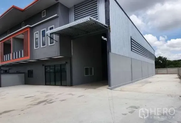 Warehouse for rent in Pathum Thani - Side elevation showing a covered loading bay with metal cladding and ample drive-through space.