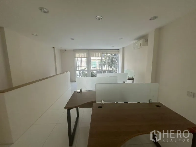 Home Office for rent in Bang Na, Bangkok - Another angle of the workstation zone showing multiple desks and windows.