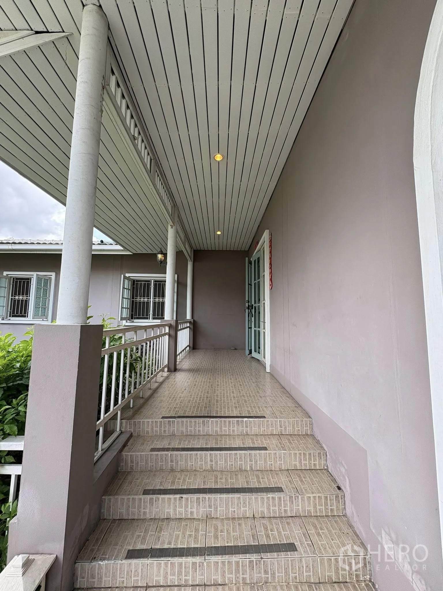 独立式住宅 出售在Phra Khanong, Bangkok - 长条有顶露台，台阶与栏杆，顶置照明。