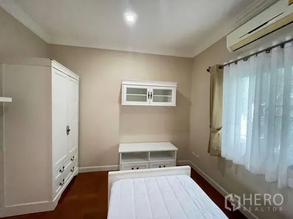 独立式住宅 出租在Mueang Nonthaburi, Nonthaburi - 温馨卧室，白色衣柜与矮柜，分体空调与纱帘采光窗。