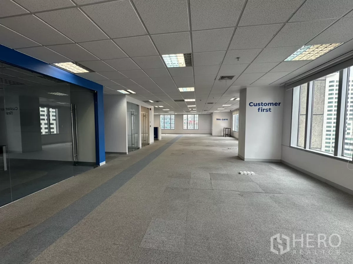 Office Space for rent in Watthana, Bangkok - Expansive open-plan office with carpet flooring, grid ceiling lights and large windows.