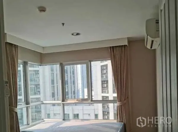 คอนโด ให้เช่าในHuai Khwang, Bangkok - ห้องนอนมุมกระจก วิวเมือง ผ้าม่านสีเบจ พร้อมแอร์ผนัง