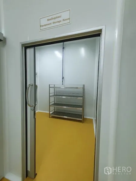 工厂 出售在Lam Luk Ka, Pathum Thani - 设备储藏间，配不锈钢层架，从推拉门处可见。