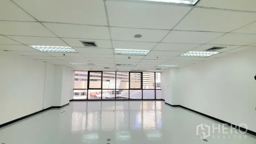 办公空间 出租在Watthana, Bangkok - 明亮的开放式办公区，亮面地坪、格栅天花灯，整面大窗享城市景观。