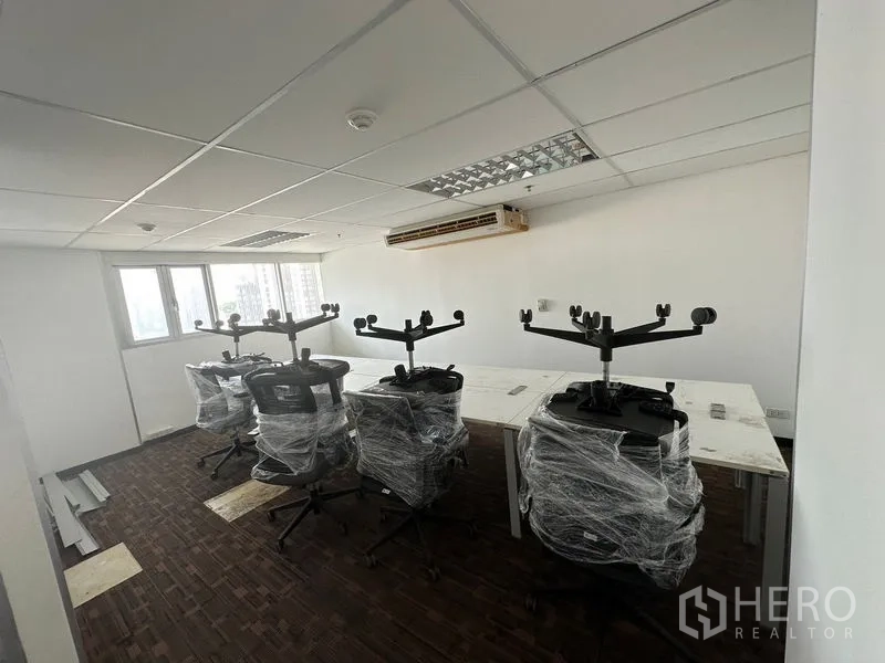 办公空间 出租在Watthana, Bangkok - 开放式工位区，包膜的新办公椅与长桌，临窗采光。