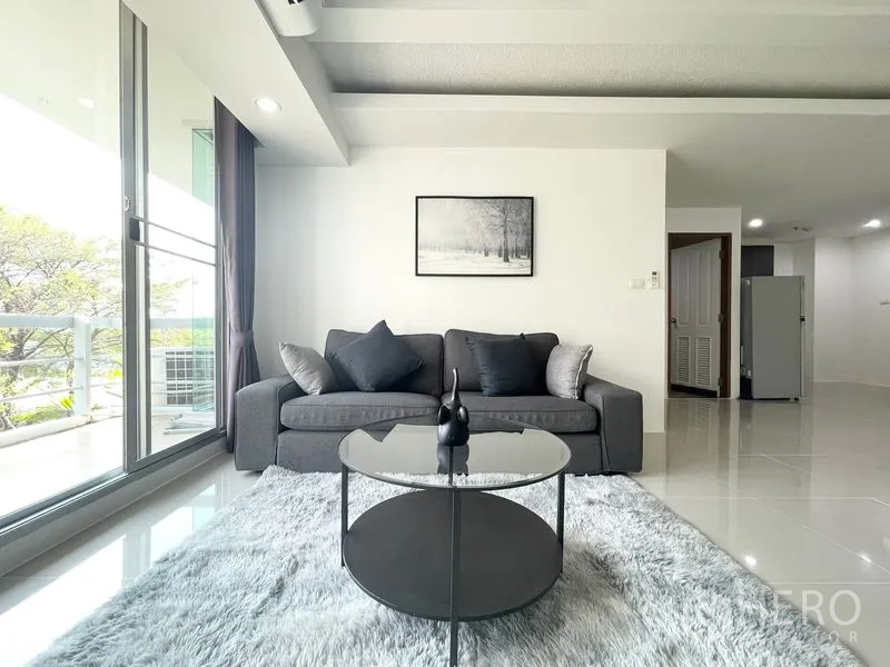 คอนโด for rent in Khlong Toei, Bangkok - โซฟาสีเท้าบนพรมฟู นั่งเล่นข้างระเบียง