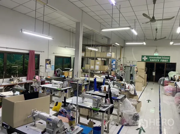Factory for rent in Prawet, Bangkok - Sewing workshop area with industrial machines, storage shelves and tiled floors.