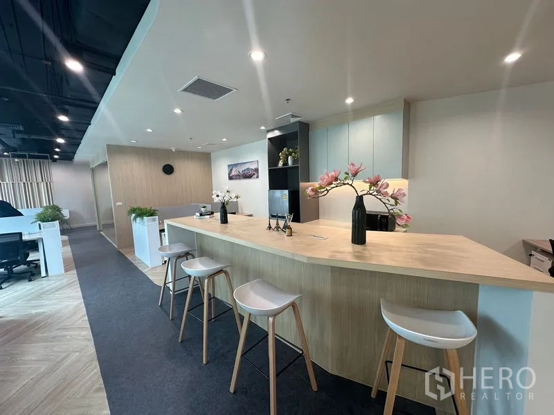 Office Space for rent - Bar-height counter with stools and flower vases in the shared pantry.