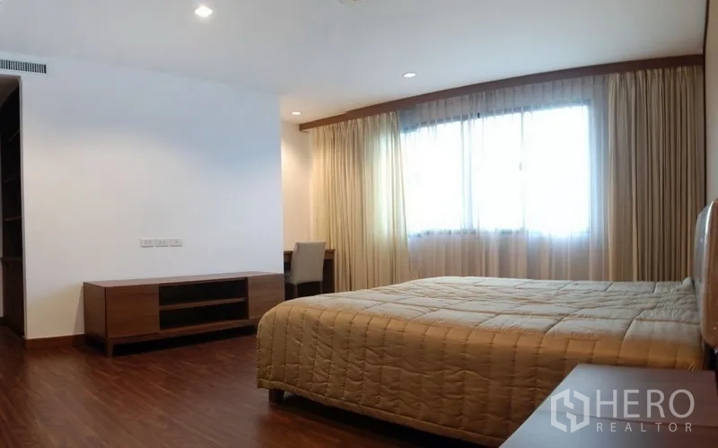 คอนโด ให้เช่าในWatthana, Bangkok - ห้องนอนตกแต่งพร้อมเตียง พื้นไม้ ตู้วางทีวี และผ้าม่านโปร่ง