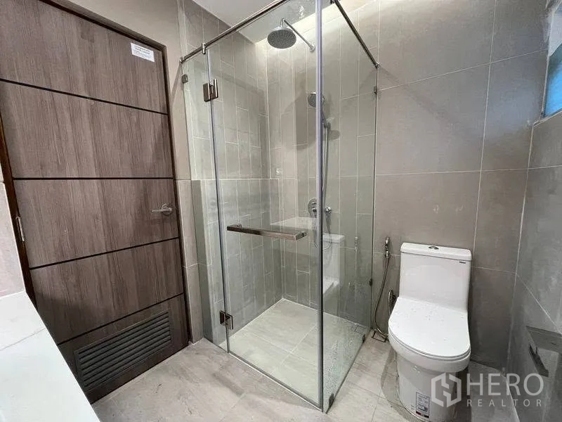 ทาวน์เฮาส์ for rent in Phra Khanong, Bangkok - ห้องน้ำปูกระเบื้องโทนกลาง ตู้อาบน้ำกระจกและโถสุขภัณฑ์.