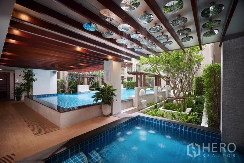 公寓 出售在Huai Khwang, Bangkok - 公寓泳池区，水景花洒、覆顶平台与景观花园。