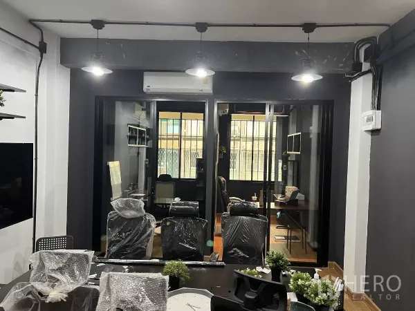 带办公室的家 出租在Pom Prap Sattru Phai, Bangkok - 从会议室望向玻璃隔间办公室，吊灯与空调清晰可见。