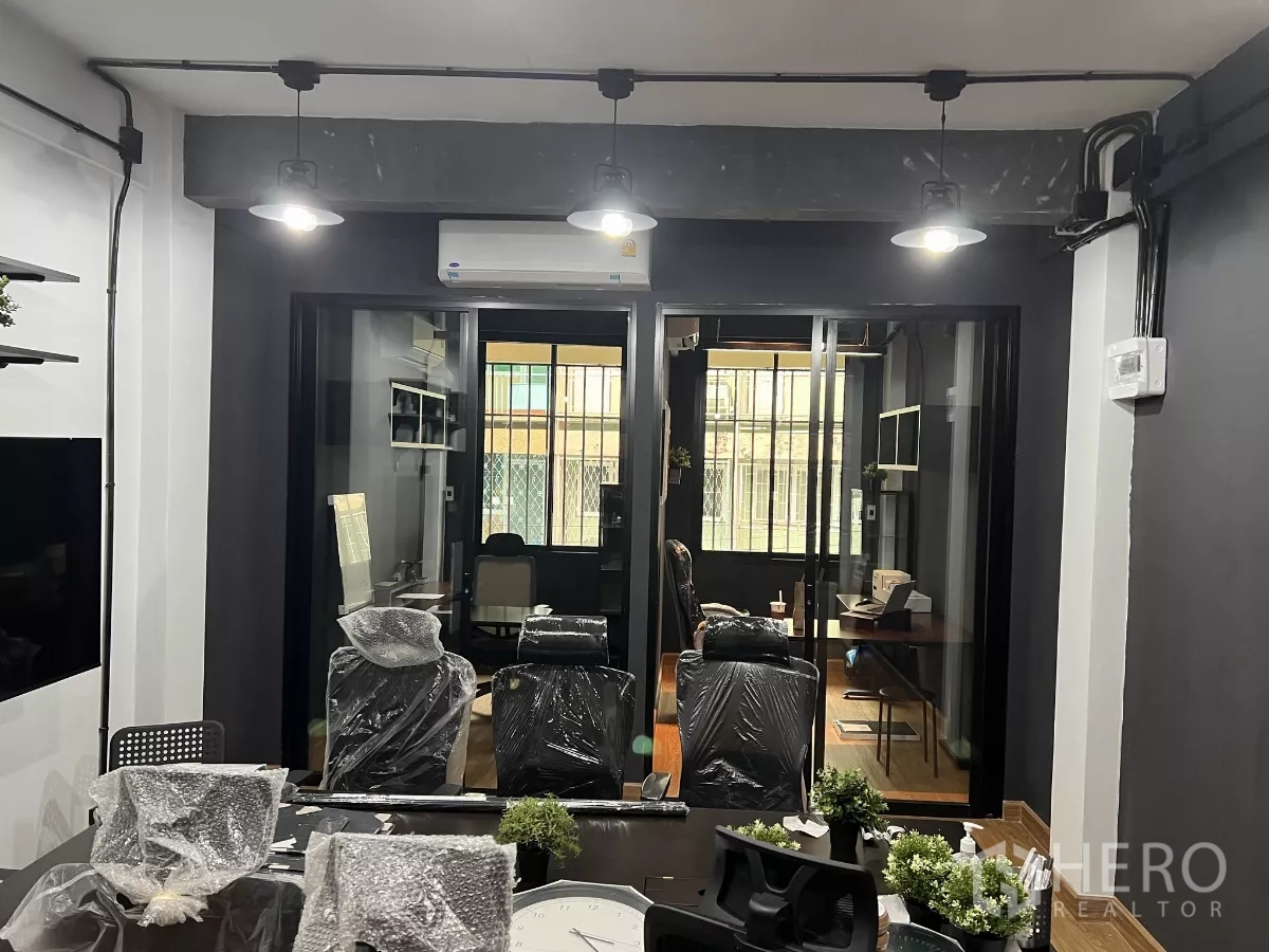 带办公室的家 出租在Pom Prap Sattru Phai, Bangkok - 从会议室望向玻璃隔间办公室，吊灯与空调清晰可见。