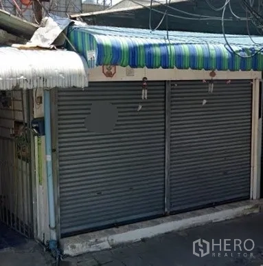 Retail Space for rent in Watthana, Bangkok - Streetfront retail exterior with double metal roller shutters and striped awning on a narrow lane.
