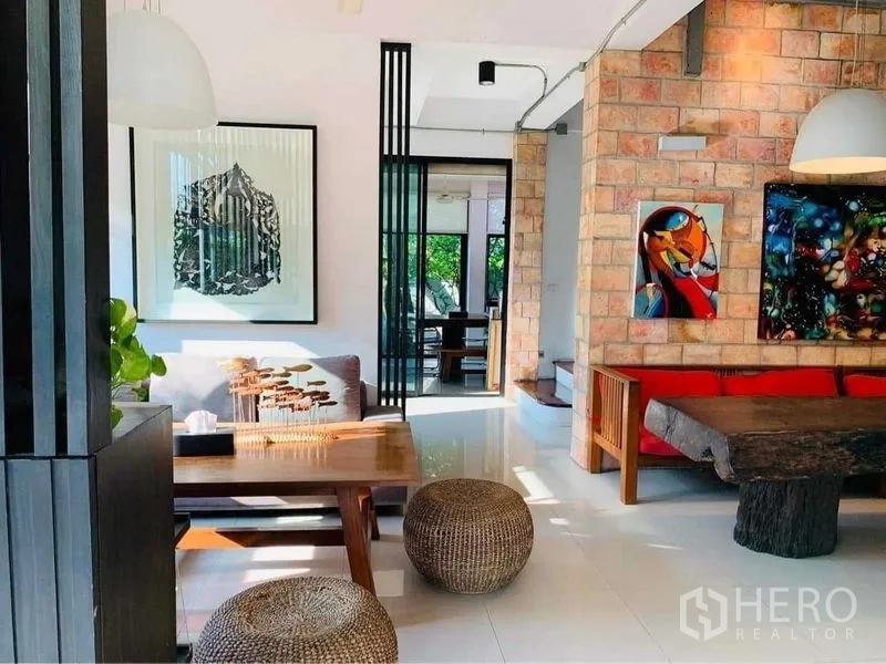 带办公室的家 出售在Wang Thonglang, Bangkok - 时尚休闲区，裸砖特色墙、现代艺术画作与木质座椅、藤编矮凳