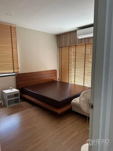 Detached House for rent in Bang Phli, Samut Prakan - Master bedroom with wooden platform bed, blinds and wall-mounted air-conditioner.