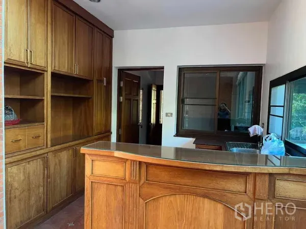 Detached House for rent in Bang Phli, Samut Prakan - Multipurpose room with built-in wooden cabinets and a bar counter beside windows.