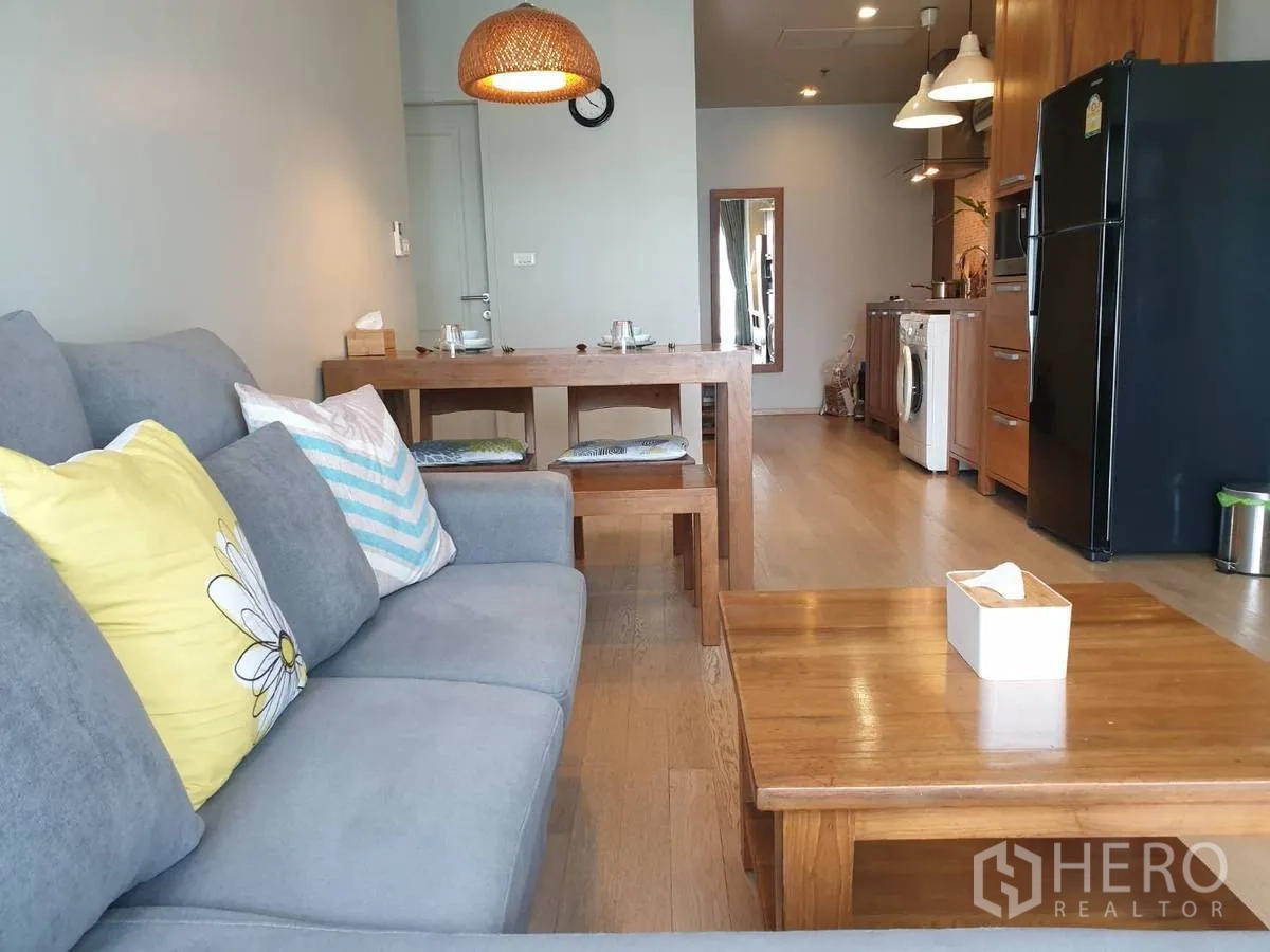 公寓 出租或出售在Bangkok - 灰色沙发和餐桌对望开放式小厨房，温馨舒适。