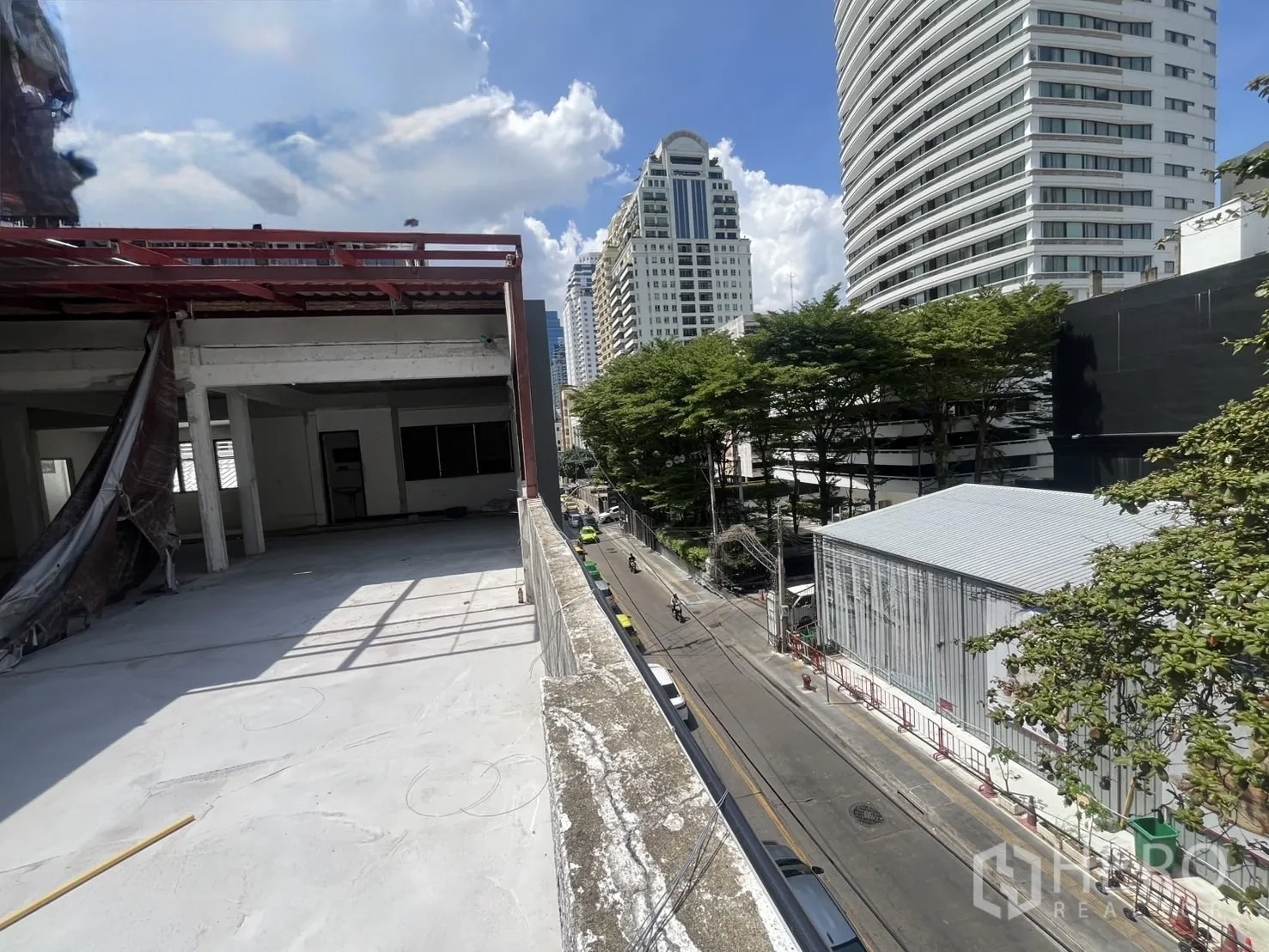 Retail Space for rent in Watthana, Bangkok - Open terrace facing the road with views of high-rise buildings and trees.